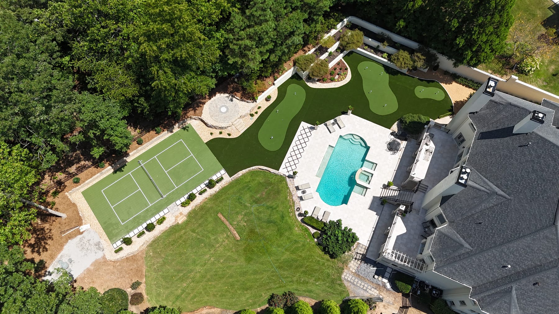 Aerial view — pickleball court, putting green and pool on estate property