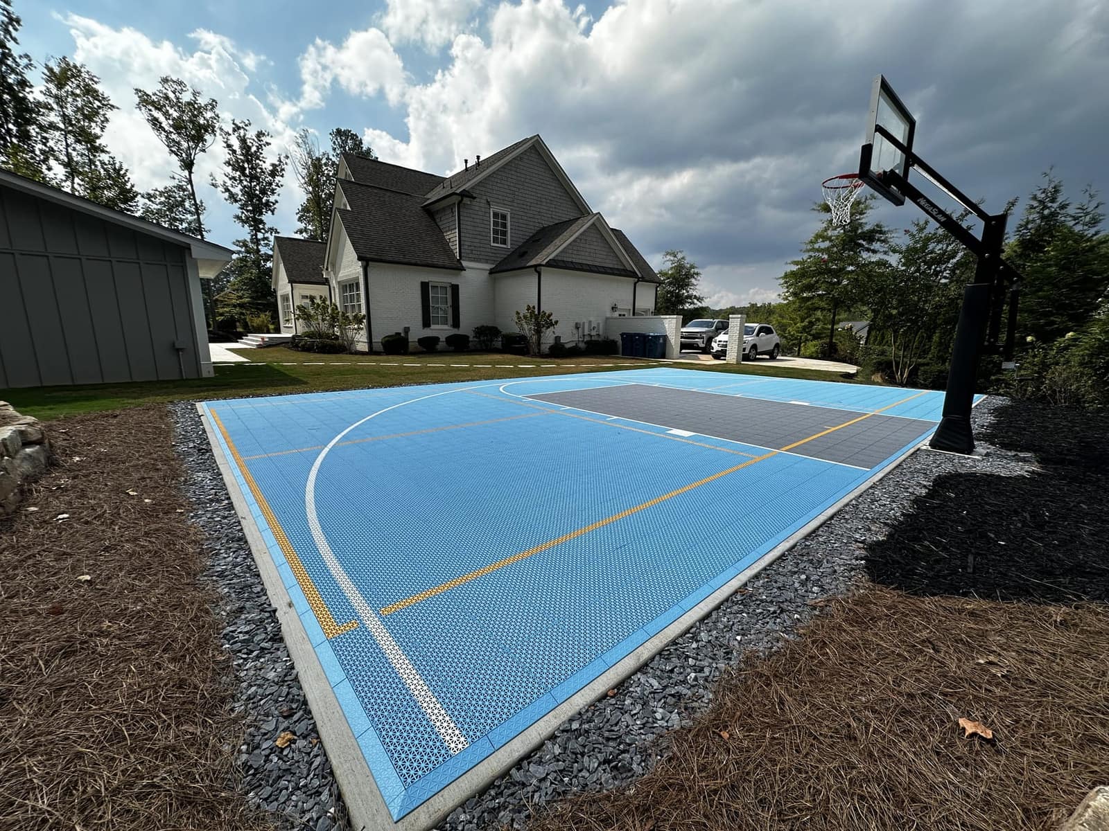 Sky blue backyard half court with charcoal key and adjustable hoop