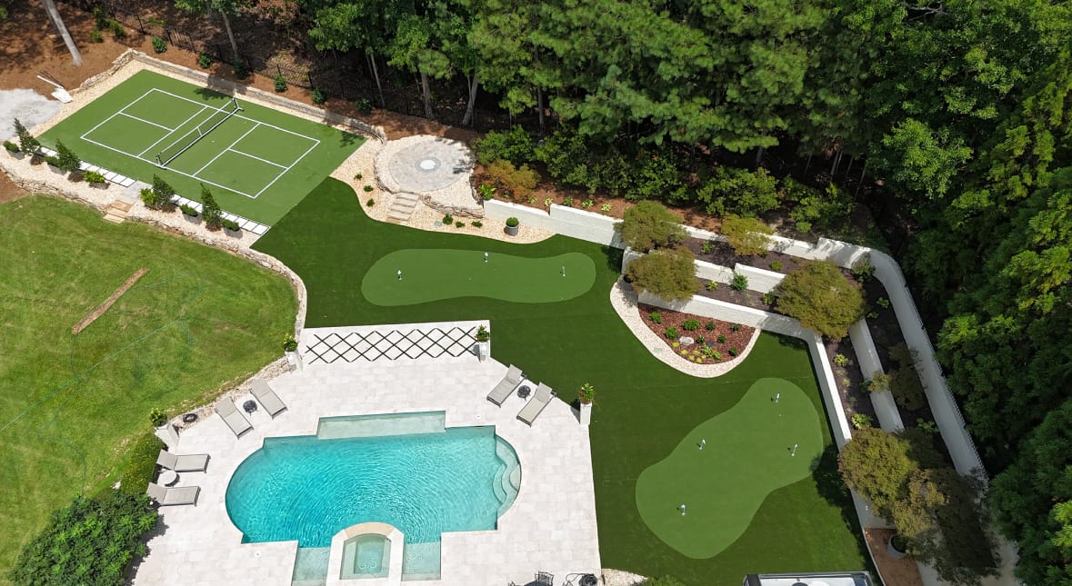 Aerial estate backyard — pickleball court, putting greens and pool