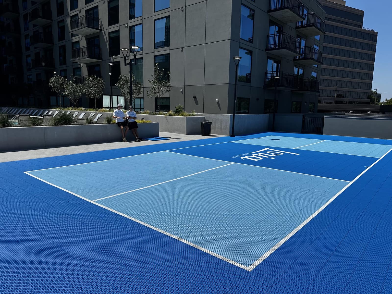 Two-tone blue pickleball court on a hotel terrace