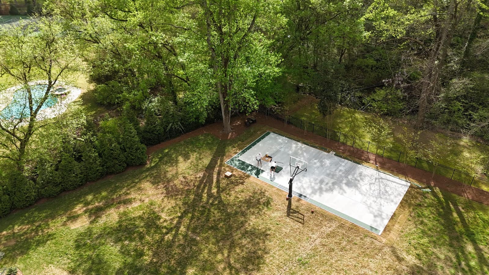 Aerial view of court installation in progress — surrounded by trees