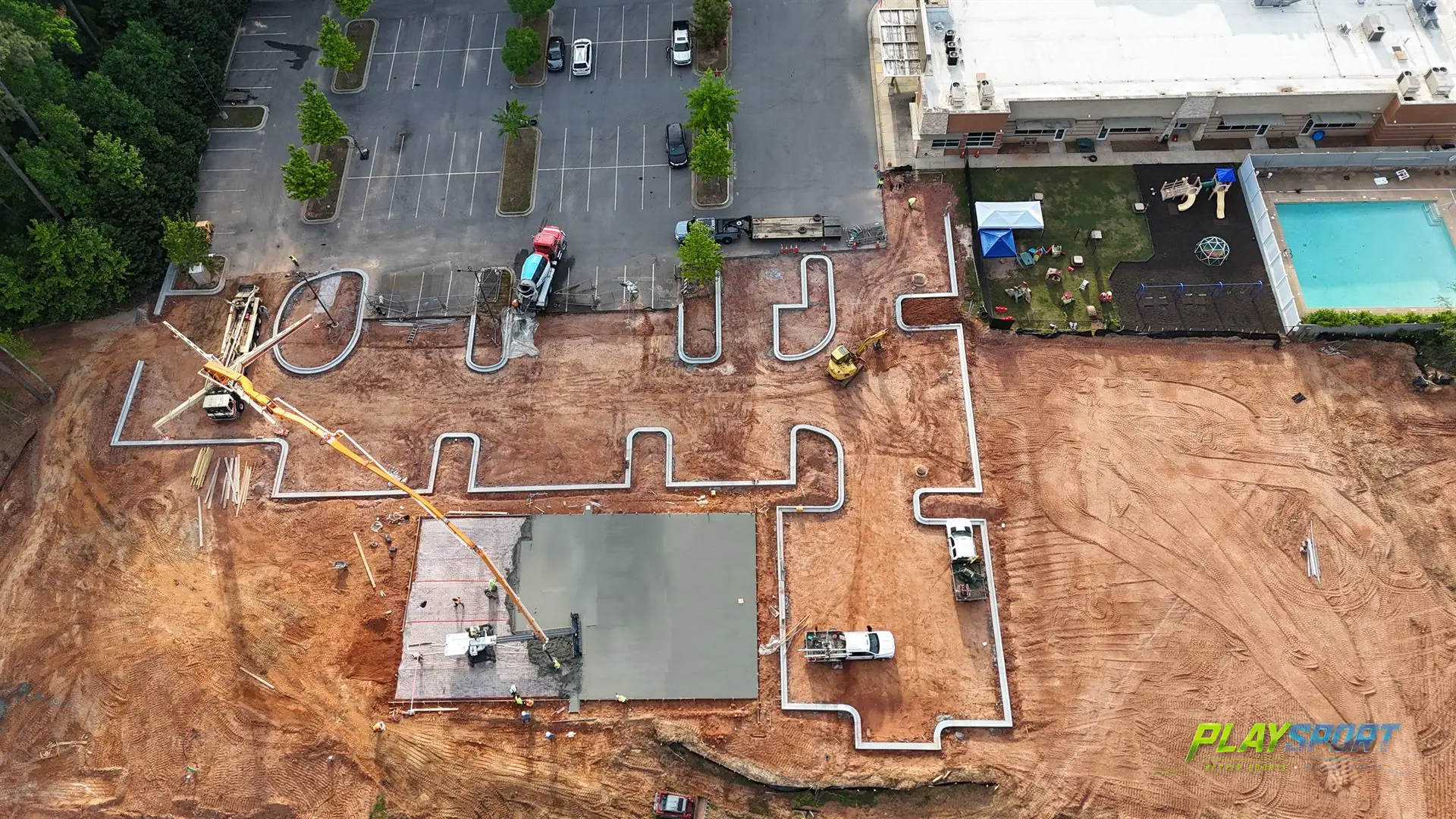 Aerial view of a sports court under construction as the fresh concrete base is poured before PlaySport modular tiles