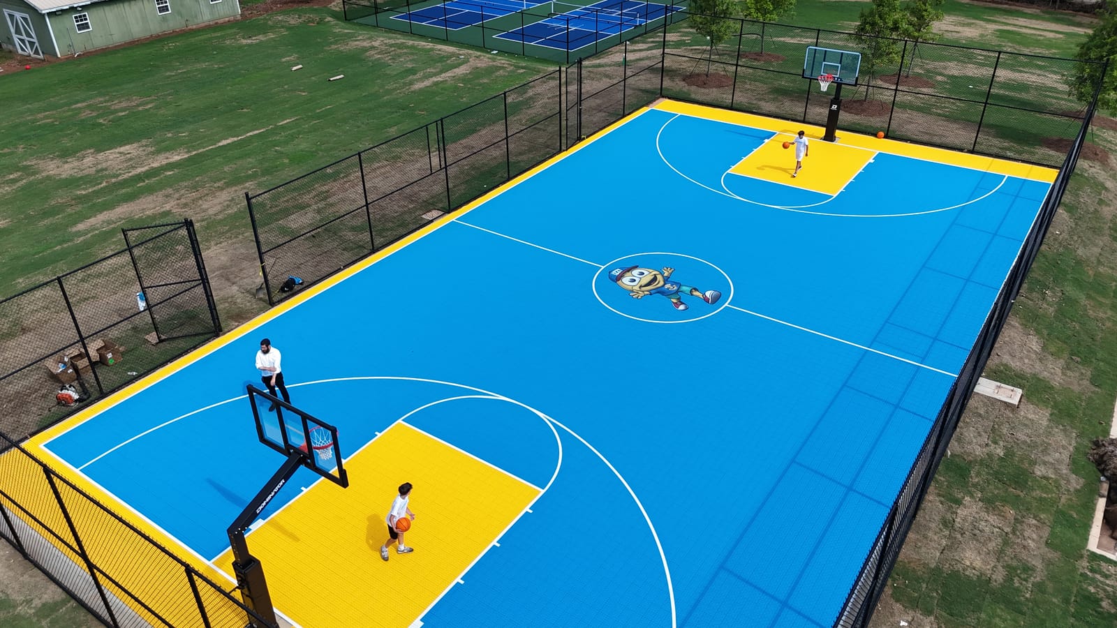 X Court Tile — elite blue and yellow basketball court installation by PlaySport Courts